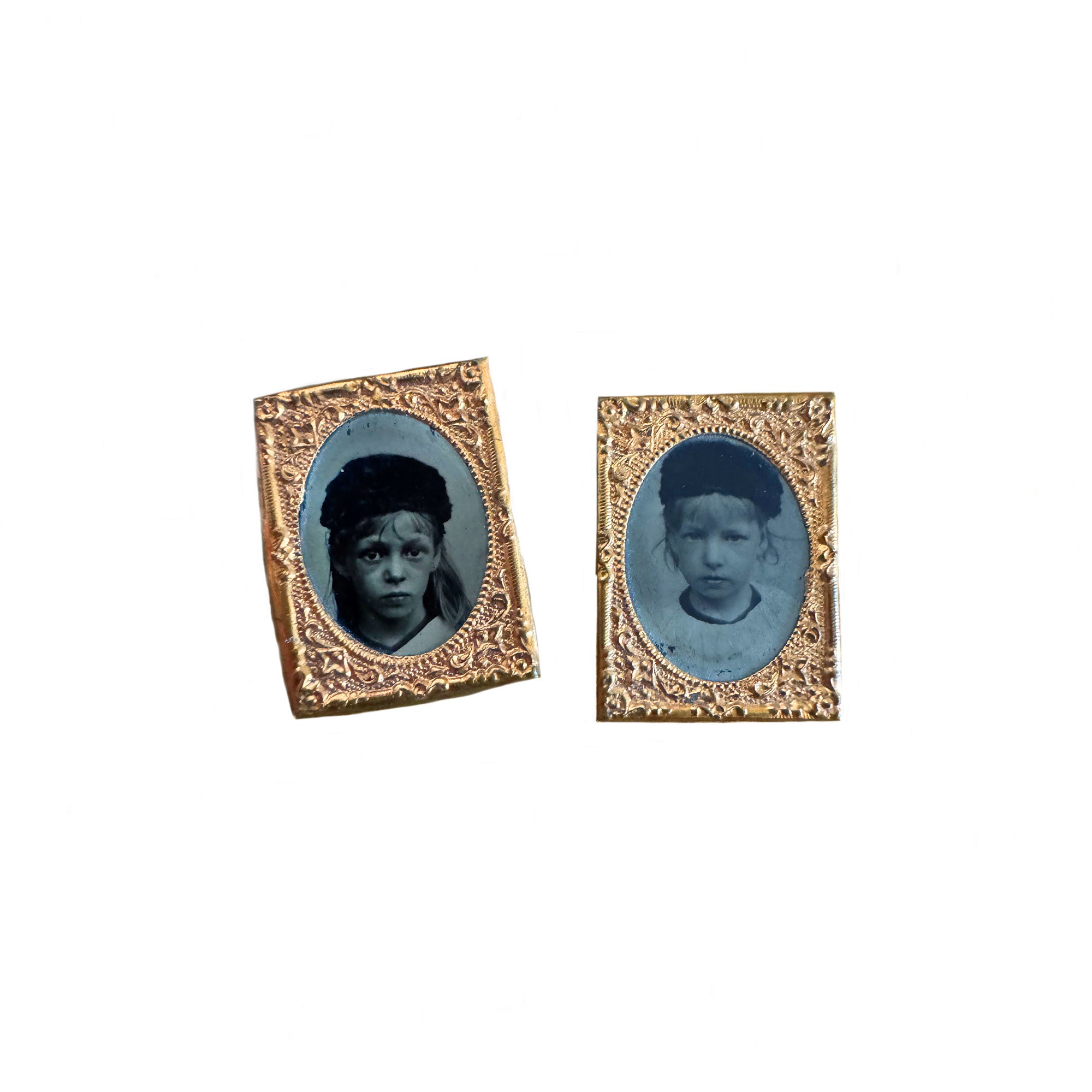 Two miniature portrait frames with blue-toned images of children on a white background.