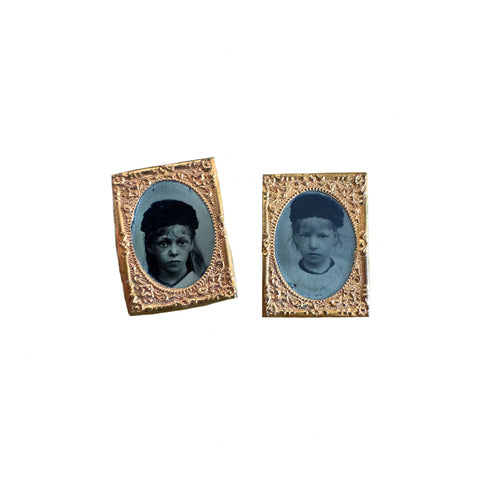 Two miniature portrait frames with blue-toned images of children on a white background.