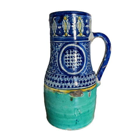 Ceramic pitcher with blue and green design on a white background