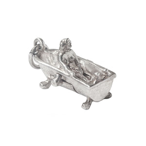 Silver charm of a person in a bathtub on a white background