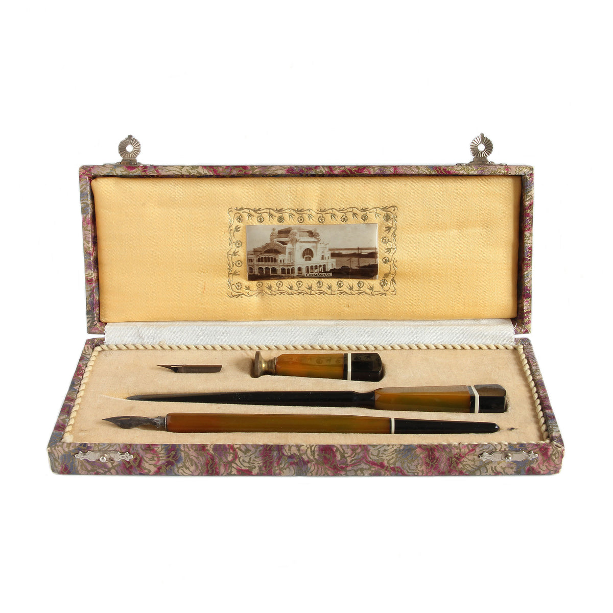 Set of writing instruments in a decorative case with a scenic photograph on a white background