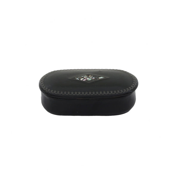 Vintage black papier mache snuff box with mother of pearl detailing on the lid, closed lid showing signs of wear.