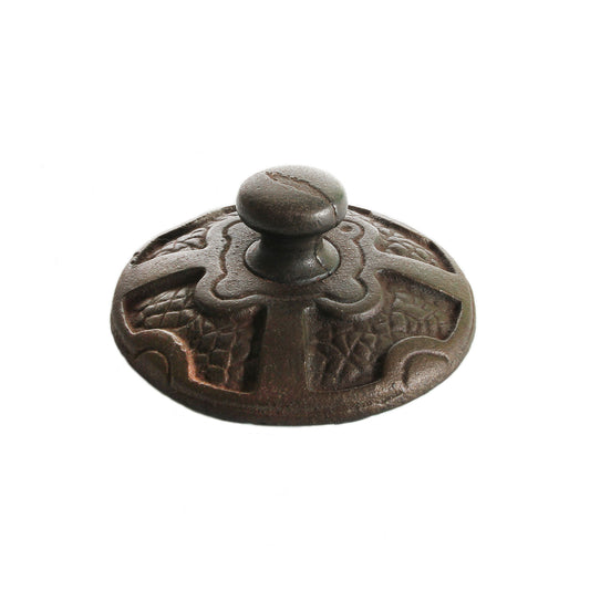 An old cast iron detailed heavy paperweight with green felt underneath and the letters 'SO' on the top edge.