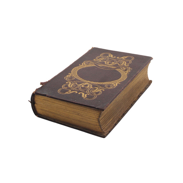 book laying down with gilt decoration and torn edge
