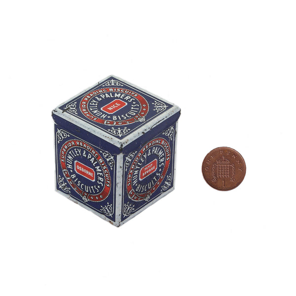 huntley and palmers miniature biscuit tin in red and blue next to a penny coin